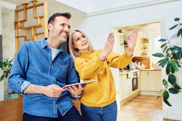Middle aged couple at home planning living room design stock photo