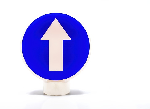 A traffic sign indicates mandatory direction for circulation. A blue arrow on a white sign