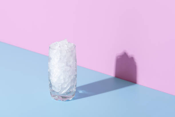 vidro de gelo em uma mesa azul em luz brilhante - crushed ice - fotografias e filmes do acervo