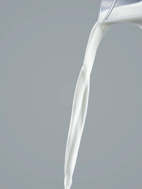 istock flowing milk from jug isolated on a gray background 1395528323
