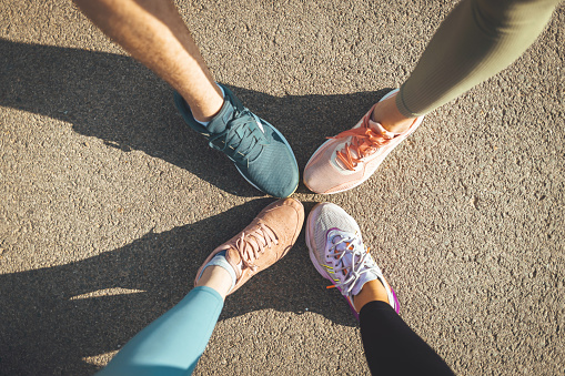 High angle of a group of sporty people's feet wearing running shoes standing together.