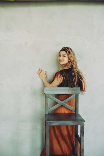 istock Girl posing with a chair on a white background. 1395530447