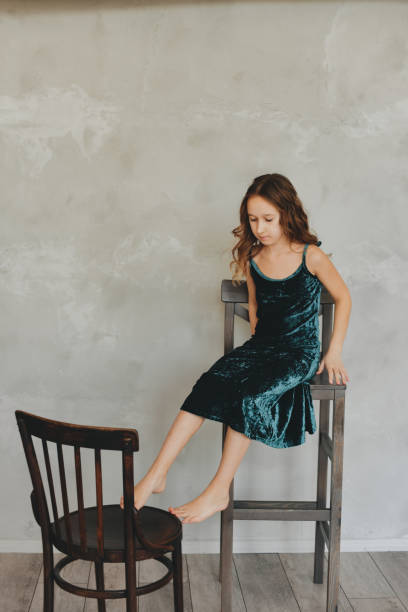 istock Girl posing sitting on a chair on a white background. 1395530669