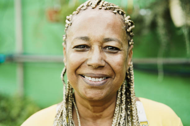 istock African woman smiling on camera while working inside greenhouse garden - Focus on face 1395531890