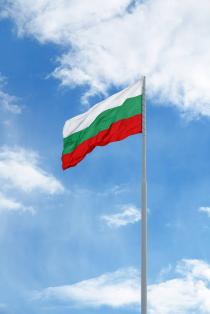 istock Bulgarian flag in front of blue sky and clouds. 1395533970