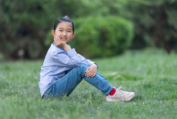 istock Little Girl Sitting on Lawn 1395536315