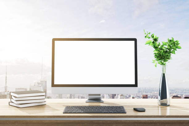 istock Close up of modern designer desktop with books, empty white computer screen, decorative plant, supplies and bright city and sky view background. Mock up, 3D Rendering. 1395536450
