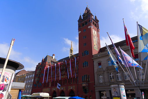 Red city hall at the medieval old town of City of Basel on a blue cloudy spring day. Photo taken April 27th, 2022, Basel, Switzerland.