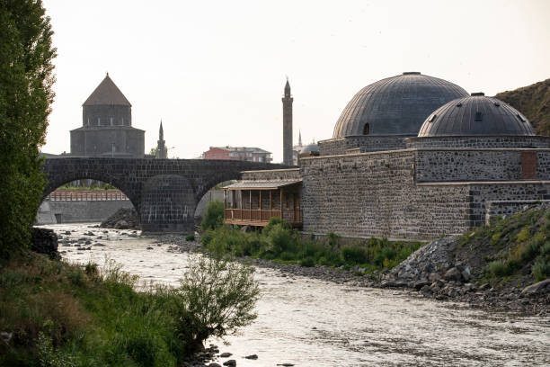 Ancient stone bridge across Kars River & Kars Castle - main tourist attractions of Kars, Turkey. Near flag (on castle) are portrait of Ataturk & writing in Turkish 'Motherland remembers you' Ancient stone bridge across Kars River & Kars Castle - main tourist attractions of Kars, Turkey. Near flag (on castle) are portrait of Ataturk & writing in Turkish 'Motherland remembers you' ani harabeleri stock pictures, royalty-free photos & images