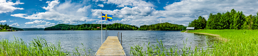 Jetty at a lake in Sweden with Swedish flag