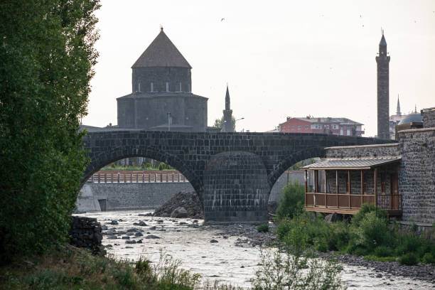Ancient stone bridge across Kars River & Kars Castle - main tourist attractions of Kars, Turkey. Near flag (on castle) are portrait of Ataturk & writing in Turkish 'Motherland remembers you' Ancient stone bridge across Kars River & Kars Castle - main tourist attractions of Kars, Turkey. Near flag (on castle) are portrait of Ataturk & writing in Turkish 'Motherland remembers you' ani harabeleri stock pictures, royalty-free photos & images
