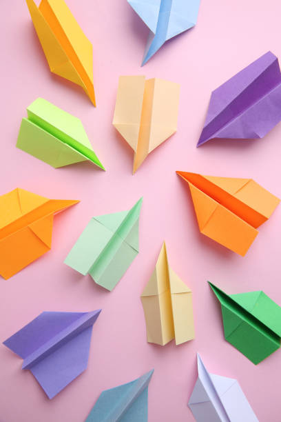 istock Many colorful paper planes on pink background, flat lay. Diversity concept 1395543303