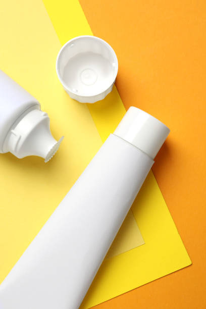 istock Blank tubes of toothpaste on color background, flat lay 1395543435