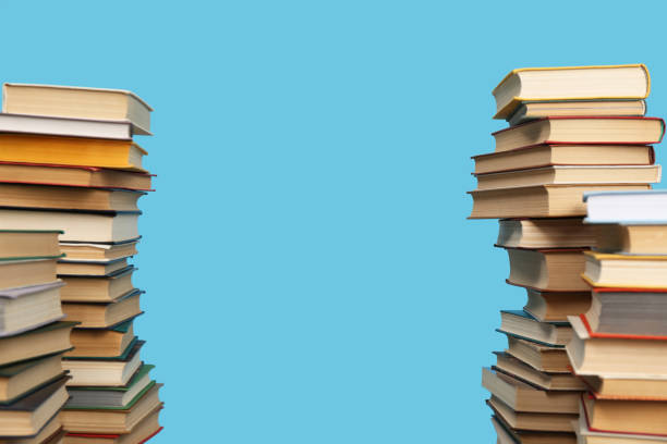 istock Many hardcover books on turquoise background, space for text. Library material 1395543571