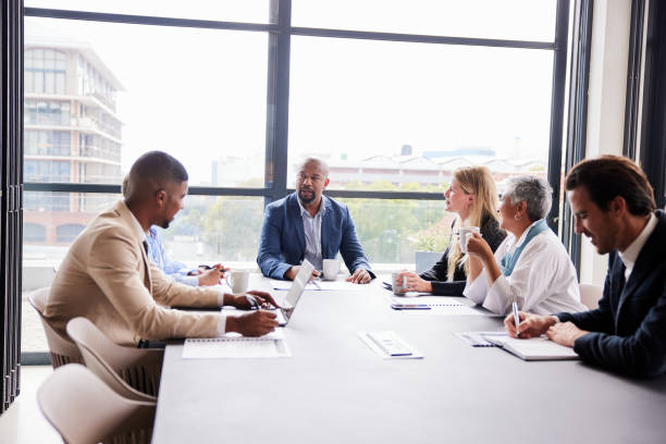 istock Manager and diverse staff having a meeting around a boardroom table 1395544813