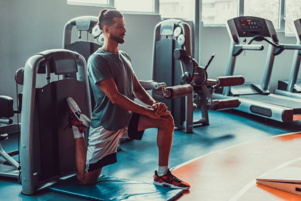 istock Handsome man stretching legs in gym before workout, stock photo 1395545546