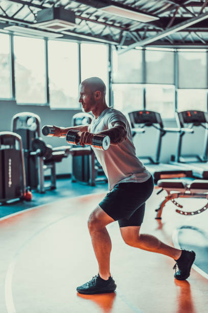 istock Handsome man pulling on rubber band on a track in the gym, stock photo 1395546442