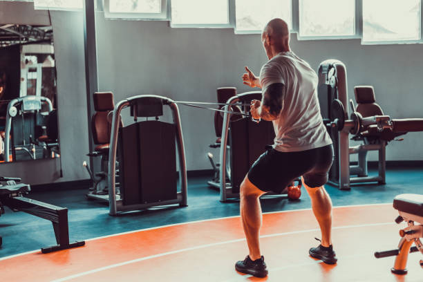 istock Handsome man pulling on rubber band on a track in the gym, stock photo 1395547097