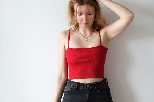A woman dressed red top and black jeans.