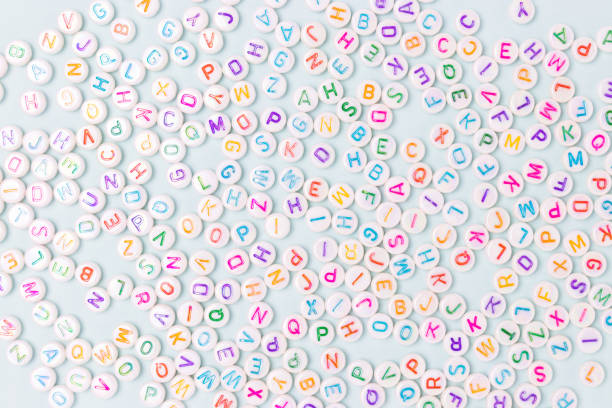 Beads with letters scattered on a blue background. Beads with letters scattered on a blue pastel background. Bead stock pictures, royalty-free photos & images