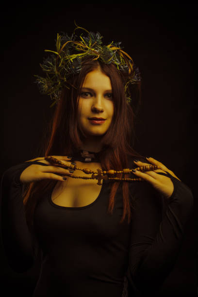 Beautiful woman in wreath over dark background