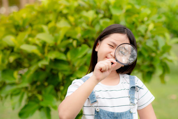 istock A girl using a magnifying glass. Learning outside the classroom. 1395551582