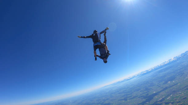 istock Skydivers fall through clear skies, aerial flight 1395553253