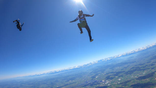 istock Skydivers fall through clear skies, aerial flight 1395553339