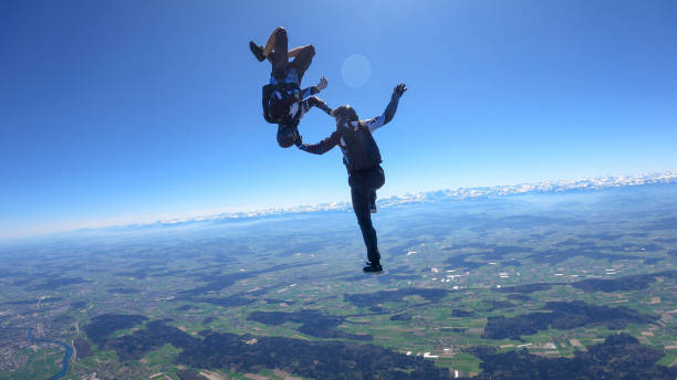 istock Skydivers fall through clear skies, aerial flight 1395553364