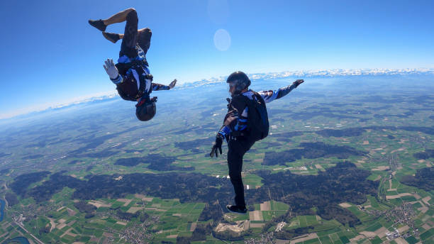 istock Skydivers fall through clear skies, aerial flight 1395553372