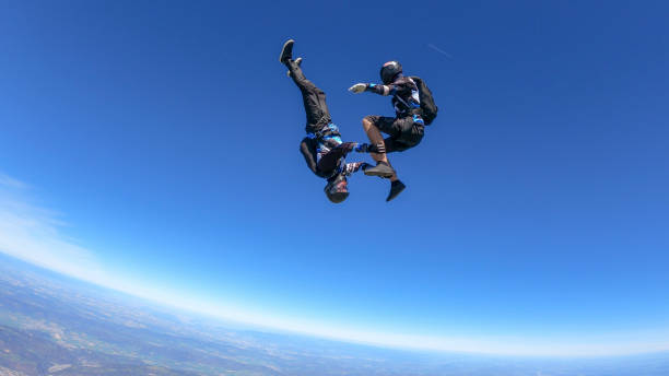 istock Skydivers fall through clear skies, aerial flight 1395553402