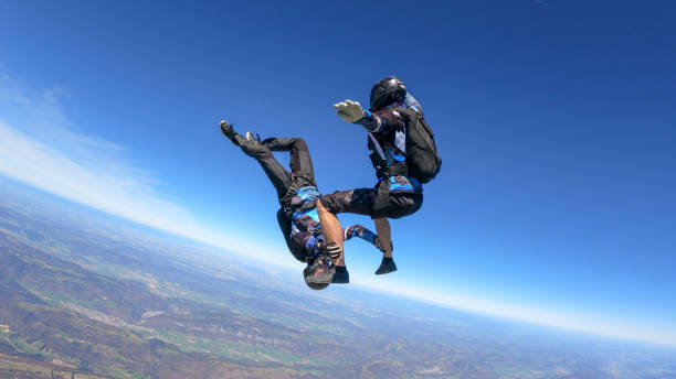 istock Skydivers fall through clear skies, aerial flight 1395553430