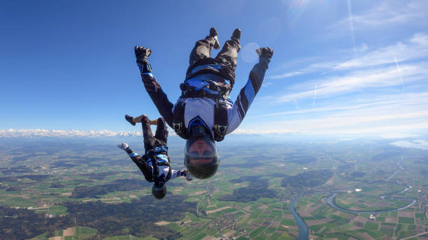 istock Skydivers fall through clear skies, aerial flight 1395553528
