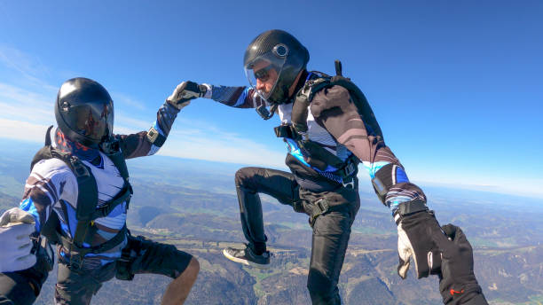 istock Skydivers fall through clear skies, aerial flight 1395553571
