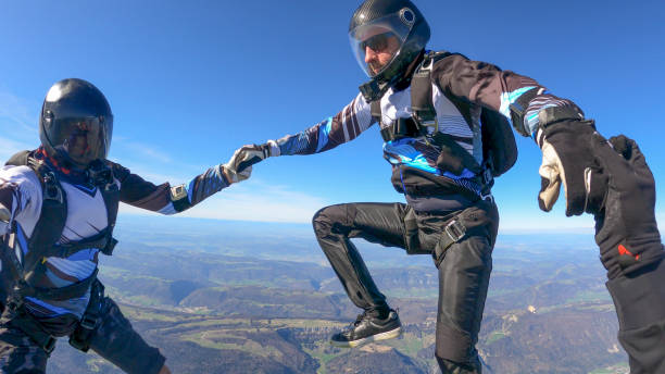 istock Skydivers fall through clear skies, aerial flight 1395553579