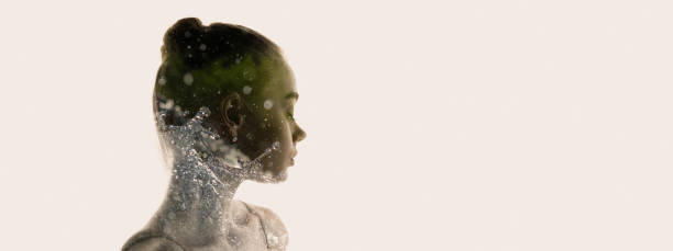 概念イメージ。若い柔らかい女性の透明なシルエットと水は、灰色の背景の上に孤立した草の周りに飛び散ります - symmetry individuality human face reflection ストックフォトと画像