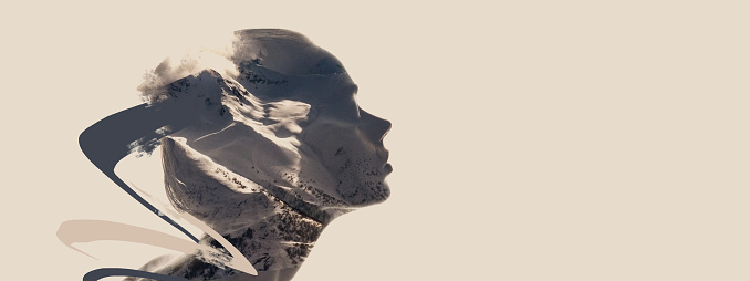 Conceptual image. Profile silhouette of young transparent woman and nature landscape of snowy mountains isolated over light grey background. Human and nature cooperation. Double exposure effect.