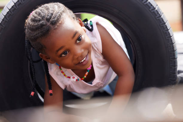 ujęcie uroczej dziewczynki bawiącej się na zewnątrz - playing child playful schoolyard zdjęcia i obrazy z banku zdjęć