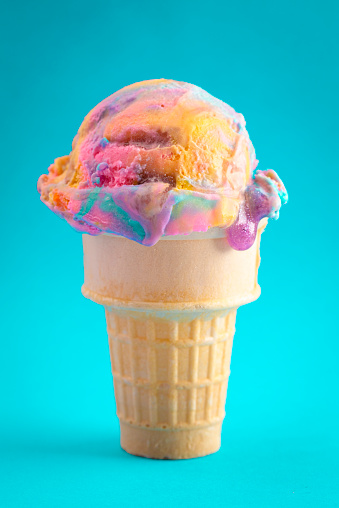 A Single Scoop of Unicorn Colored Ice Cream in a Cone