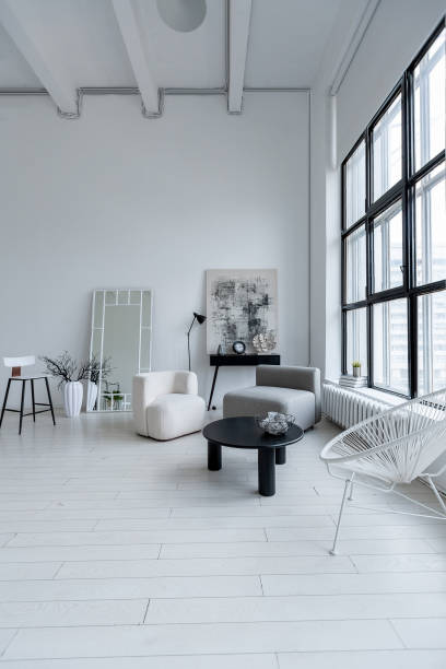 istock modern minimalistic interior design of light bright monochrome room with black and white furniture, clean white walls and huge windows 1395558936