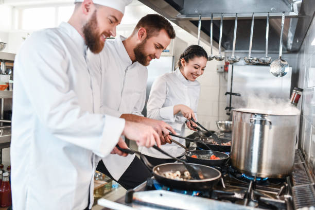 istock Smiling Kitchen Team Working On A Number Of Dishes And Stew In Restaurant Kitchen 1395559096