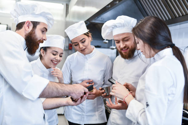 istock Recipe Exchange Via Smartphones During Work Break For Cooks In Restaurant Kitchen 1395559332