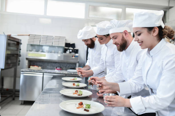 istock Cooks In Kitchen Having Competition In Plate Decoration 1395560023