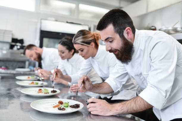 istock Cooking Competition Going Well For Cooks Preparing To Finalize Dish Topping 1395560035