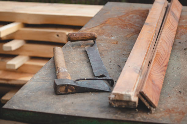 istock Traditional woodworking using old and hand tools such as an axe and planer stored on an iron table with wooden logs 1395560162