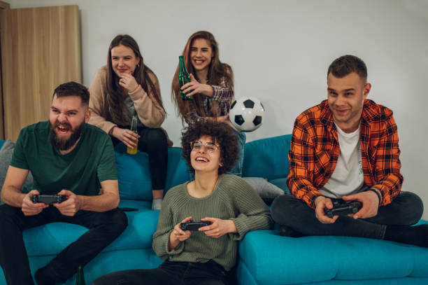 group of friends playing video games at home - gamer watching tv adult couple imagens e fotografias de stock