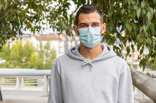 portrait of young man with face mask outdoors