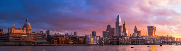 London dawn Financial District skyscrapers St Paul's Cathedral Thames panorama Golden light of sunrise illuminated the futuristic spires of City skyscrapers, the delicate span of the Millennium Bridge over the River Thames in the heart of London, UK. bankside photos stock pictures, royalty-free photos & images