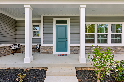 Front exterior of a large greyish blue new home in Virginia.