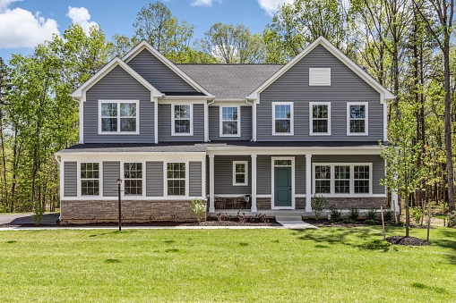 Front exterior of a large greyish blue new home in Virginia.